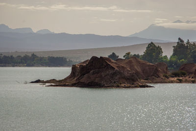 Scenic view of sea and mountains against sky