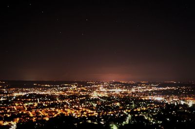 Illuminated cityscape against sky at night