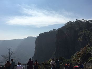 People on mountain against sky