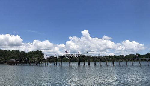 Bridge over river against sky in city