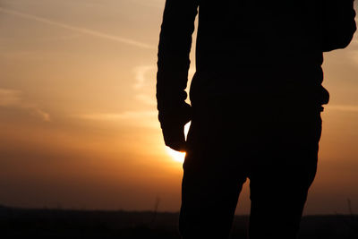 Silhouette man standing against sky during sunset