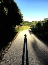 Shadow of person walking on road