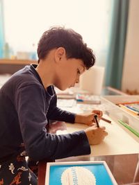 Side view of boy learning to draw concentrated