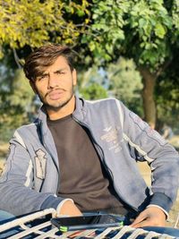 Portrait of young man against trees