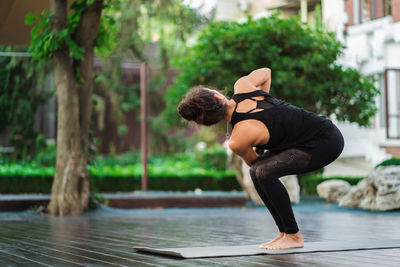 Woman exercising on mat at park