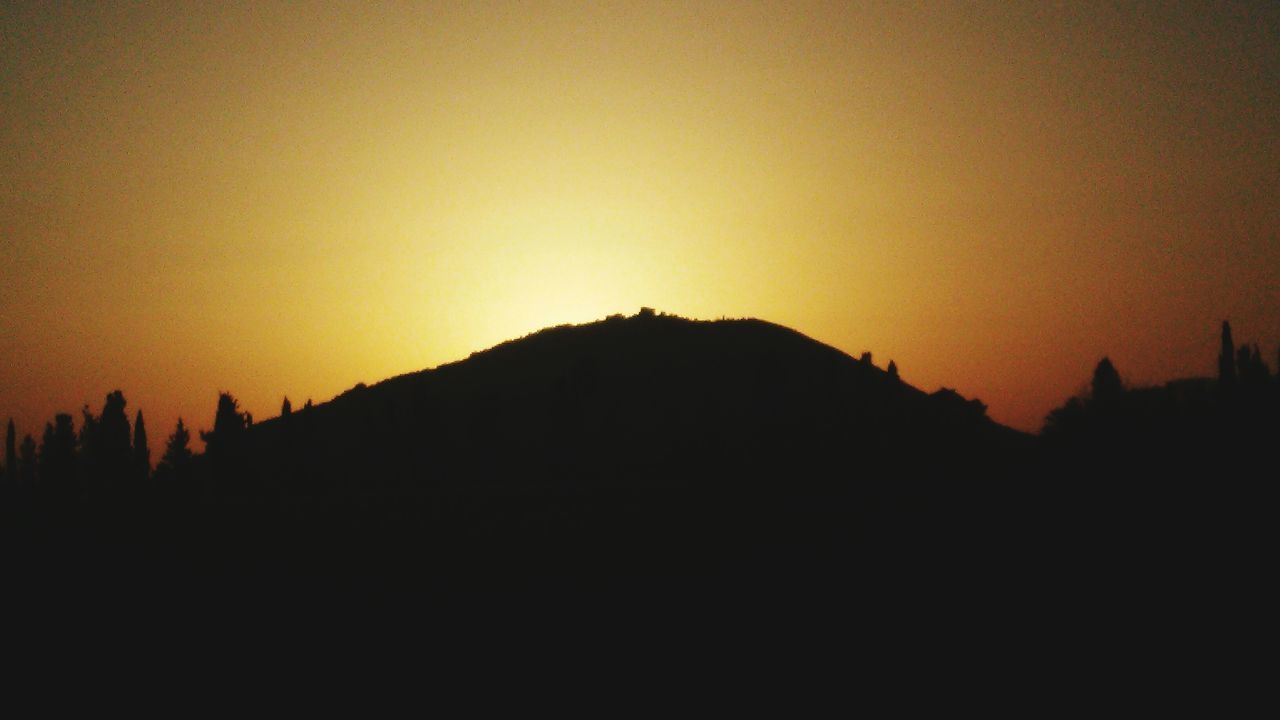 sunset, silhouette, copy space, scenics, tranquil scene, beauty in nature, tranquility, mountain, orange color, clear sky, nature, idyllic, landscape, sky, dark, mountain range, outline, dusk, outdoors, no people