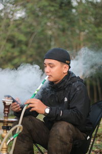 Low angle view of young man working in forest