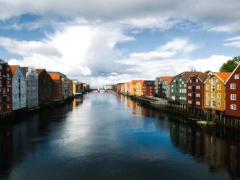 River amidst colorful buildings in city against sky