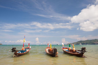 Boats moored in sea against sky