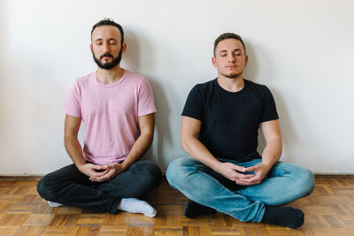 Two gay men sitting and meditating.