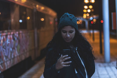 Man using mobile phone in city at night