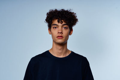 Portrait of young man against blue background