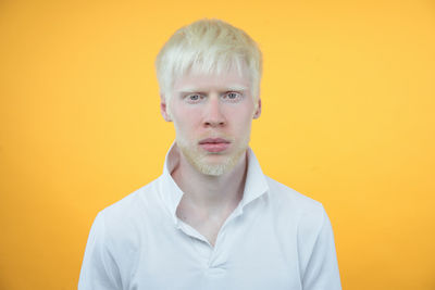 Portrait of young man against yellow background