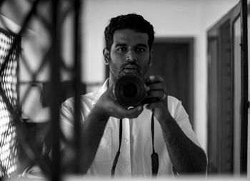 Close-up of man photographing through mirror