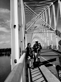 People on bridge against sky