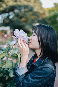 Portrait of woman holding flowering plant