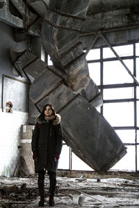 Full length portrait of man standing in abandoned building