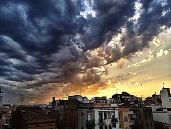 Silhouette of buildings against cloudy sky