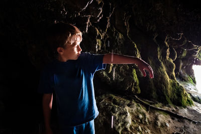 Rear view of boy standing on rock