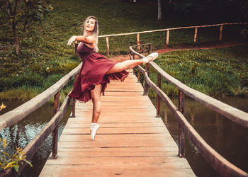 Full length of woman on footbridge against trees