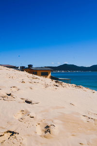 Scenic view of beach against clear blue sky