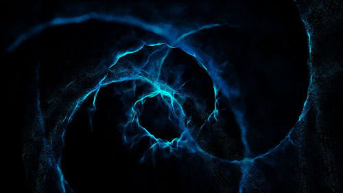 Close-up of illuminated lighting equipment against black background