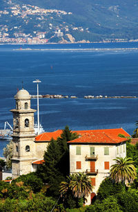 High angle view of trees and church by sea
