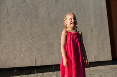 Young woman standing against wall