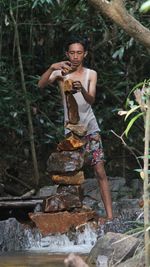 Portrait of young woman sitting on rock