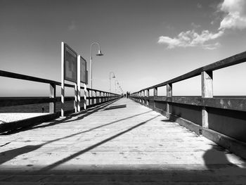 Bridge over calm sea against sky