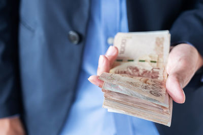 Midsection of businessman counting money