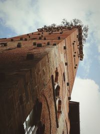 Low angle view of old building against cloudy sky