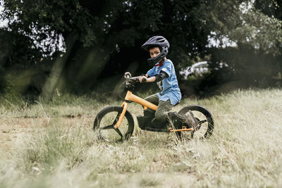 Portrait of boy riding bicycle on field