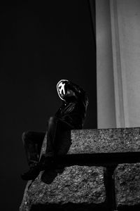 Person wearing mask against wall
