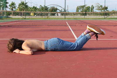 Side view of young woman lying on ball