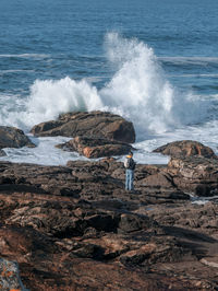 Scenic view of waves breaking on rocks at shore