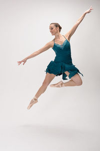 Young woman jumping against white background