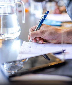 Midsection of man reading book on table