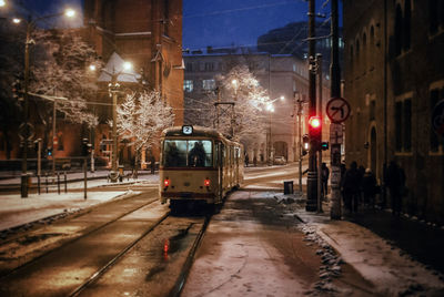 Tram moving on city street at night