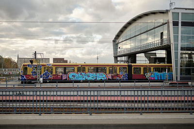 Train on railroad tracks in city against sky