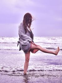 Full length of woman on beach against sky