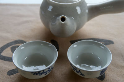 Close-up of tea cups and teapot on table