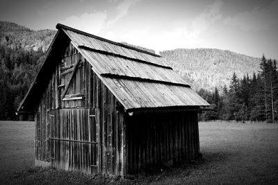 Abandoned wooden house on field against sky