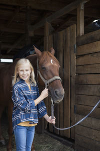 Rear view of woman standing in stable