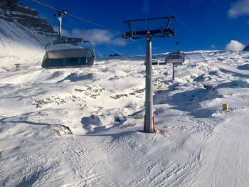 Ski lift over snowcapped mountains against sky