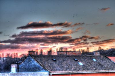 Buildings against cloudy sky at sunset