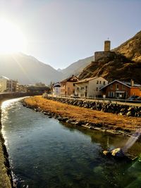 River by buildings against sky