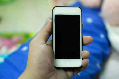 Close-up of hand holding mobile phone