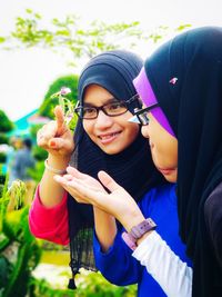 Portrait of smiling young woman holding camera