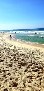 Scenic view of beach against clear blue sky